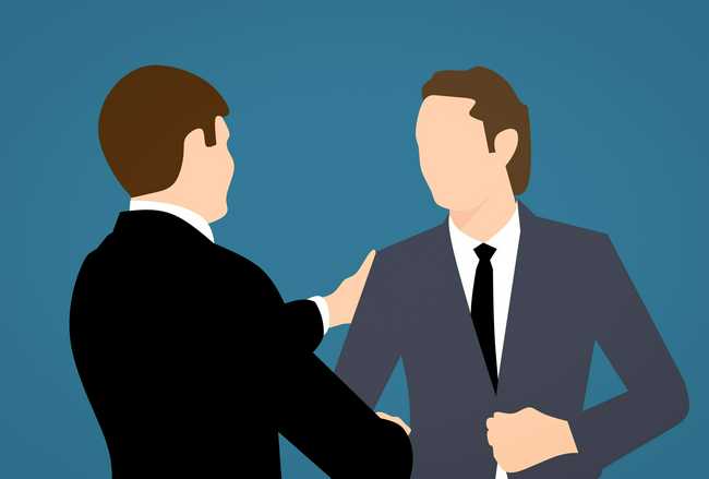 Image of two business men shaking hands in front a blue background